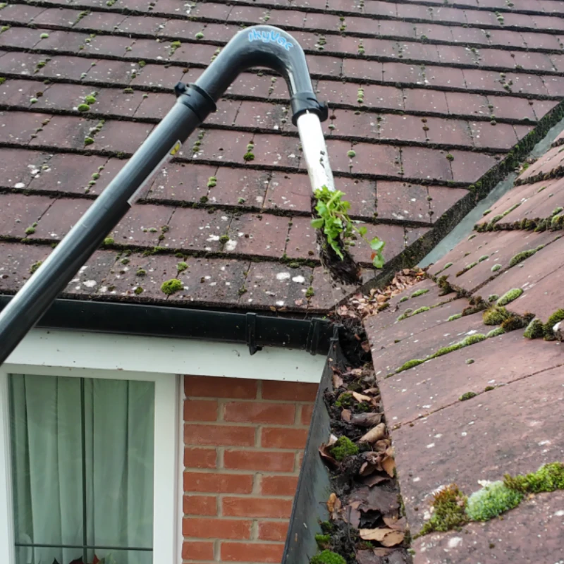 Professional gutter clearing using a high-reach gutter vacuum system