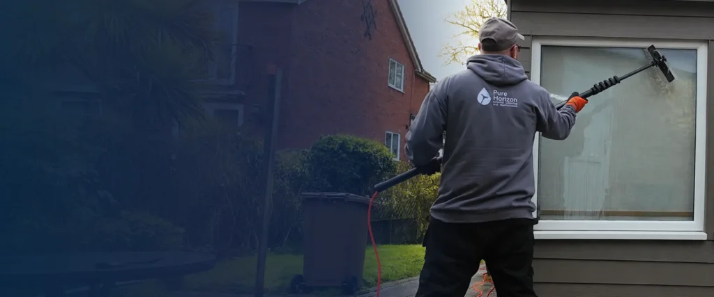 Professional window cleaner using a purified water fed pole system to clean residential windows in Suffolk